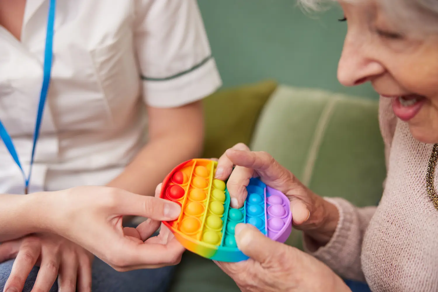 Physiotherapeutin bringt ältere Frau dazu, zu Hause einen Gummiball zu drücken